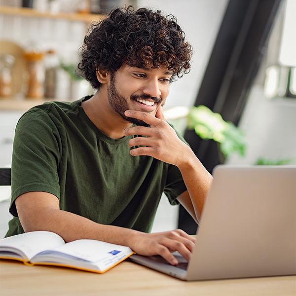 Male student using laptop to complete online education